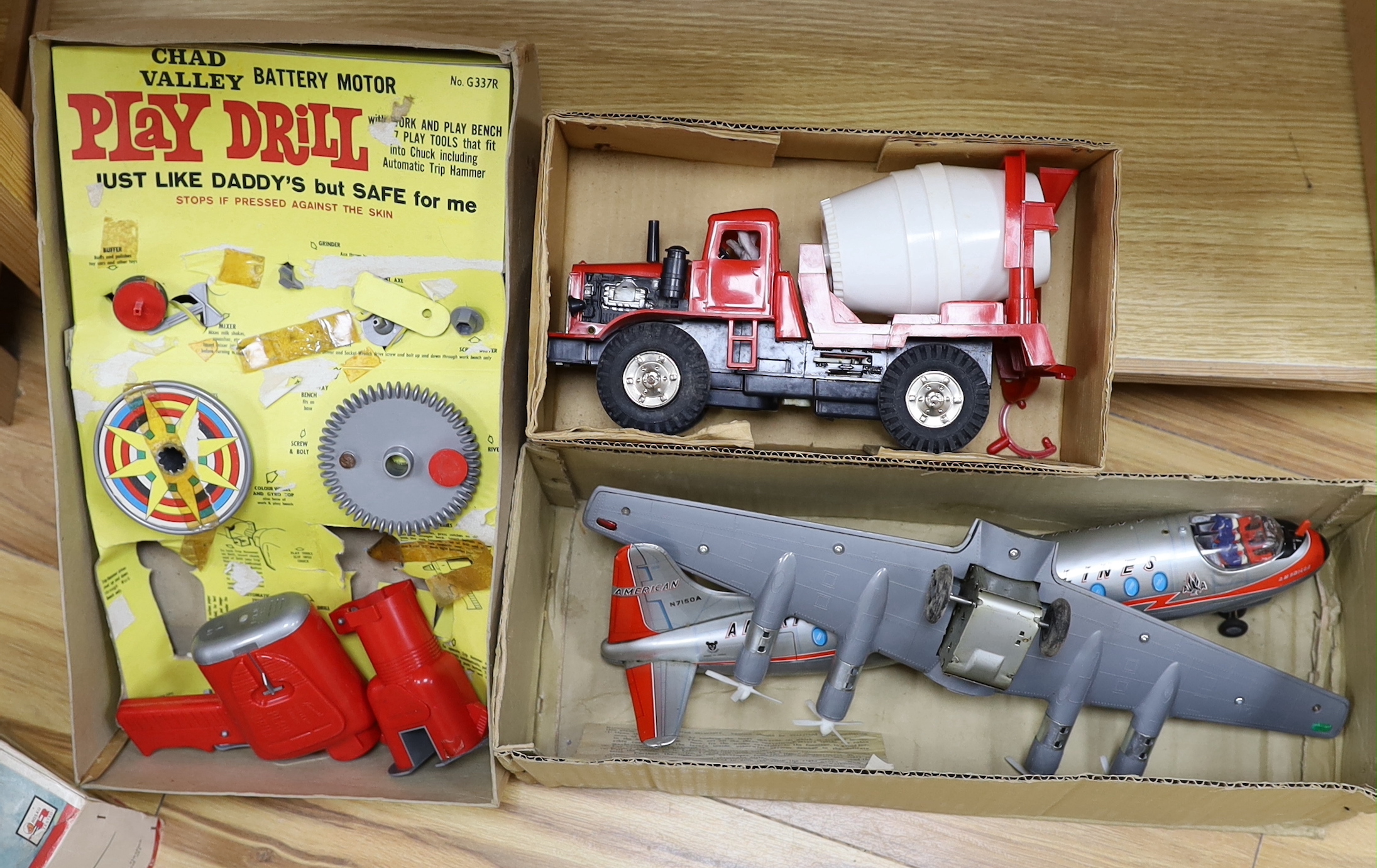 Three boxed 1960s battery operated plastic toys including a Rosho Toy tinplate and plastic airliner, a Marx Power-Brute Cement Mixer and a Chad Valley Play Drill, air liner 45cm long